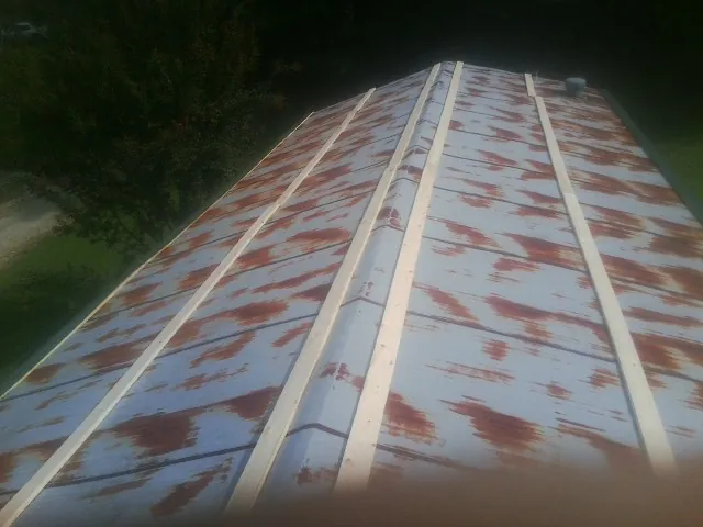 Rusted metal roof panels with new wood purlins before replacement — Storm Damage Roof Repair in Woods Hole by Roofing Brothers