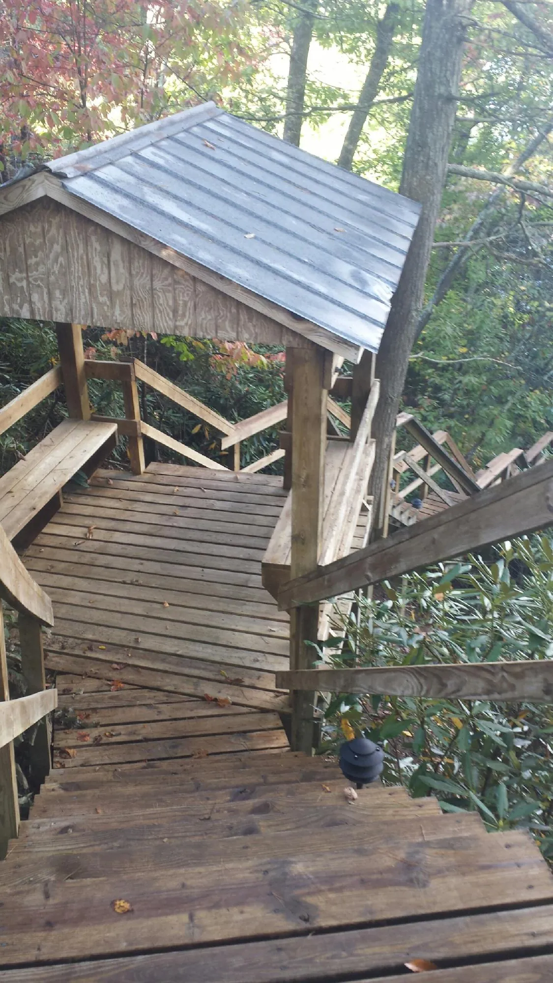 Metal roofed shelter over wooden steps on a wooded walkway — Skylight Repair & Installation work by our crew in Woods Hole