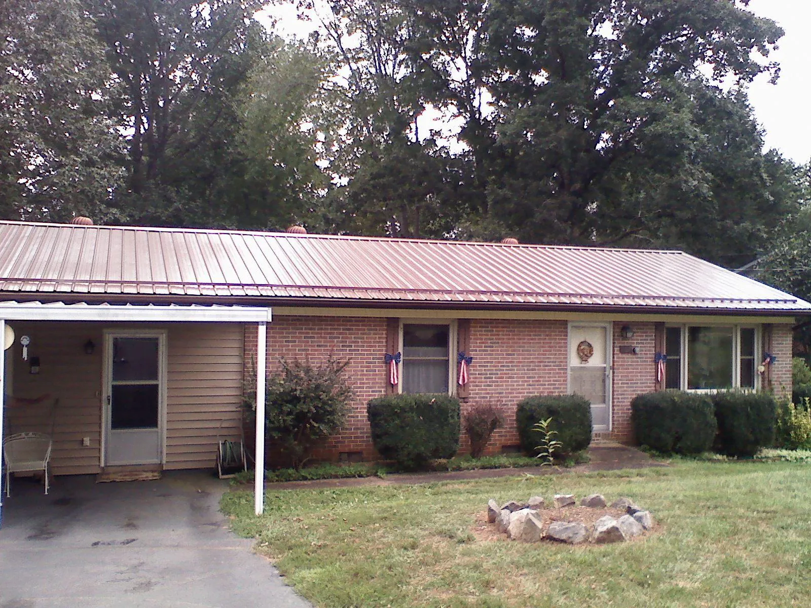 Bronze metal roof and carport on a brick ranch home — Roof Repair work by our crew in Woods Hole